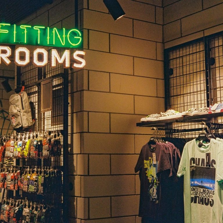 Display of clothing and shoes with a sign for fitting rooms above.
